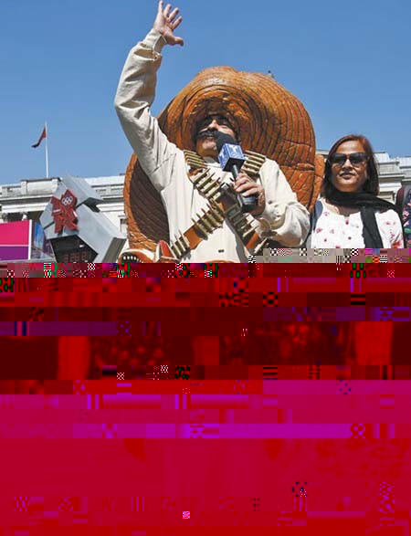 7月27日,一名墨西哥记者身穿墨西哥牛仔服在伦敦街头拍摄节目。