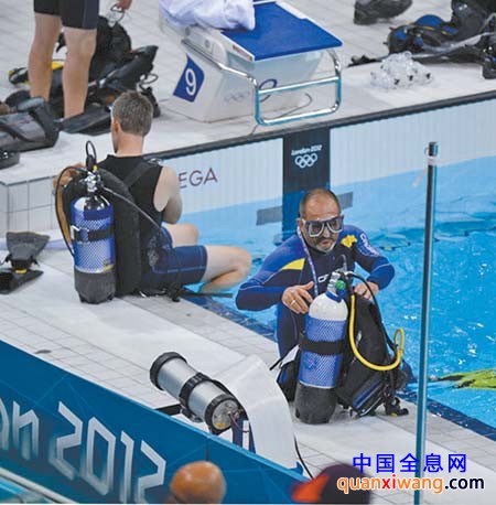 7月29日,两名外媒记者在泳道旁准备水下摄影器材。