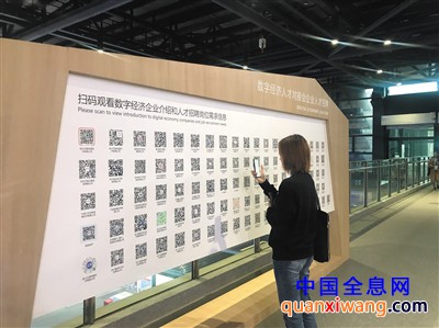 位于展馆二层的数字经济企业人才招聘二维码墙,一名观众正在扫码试用。